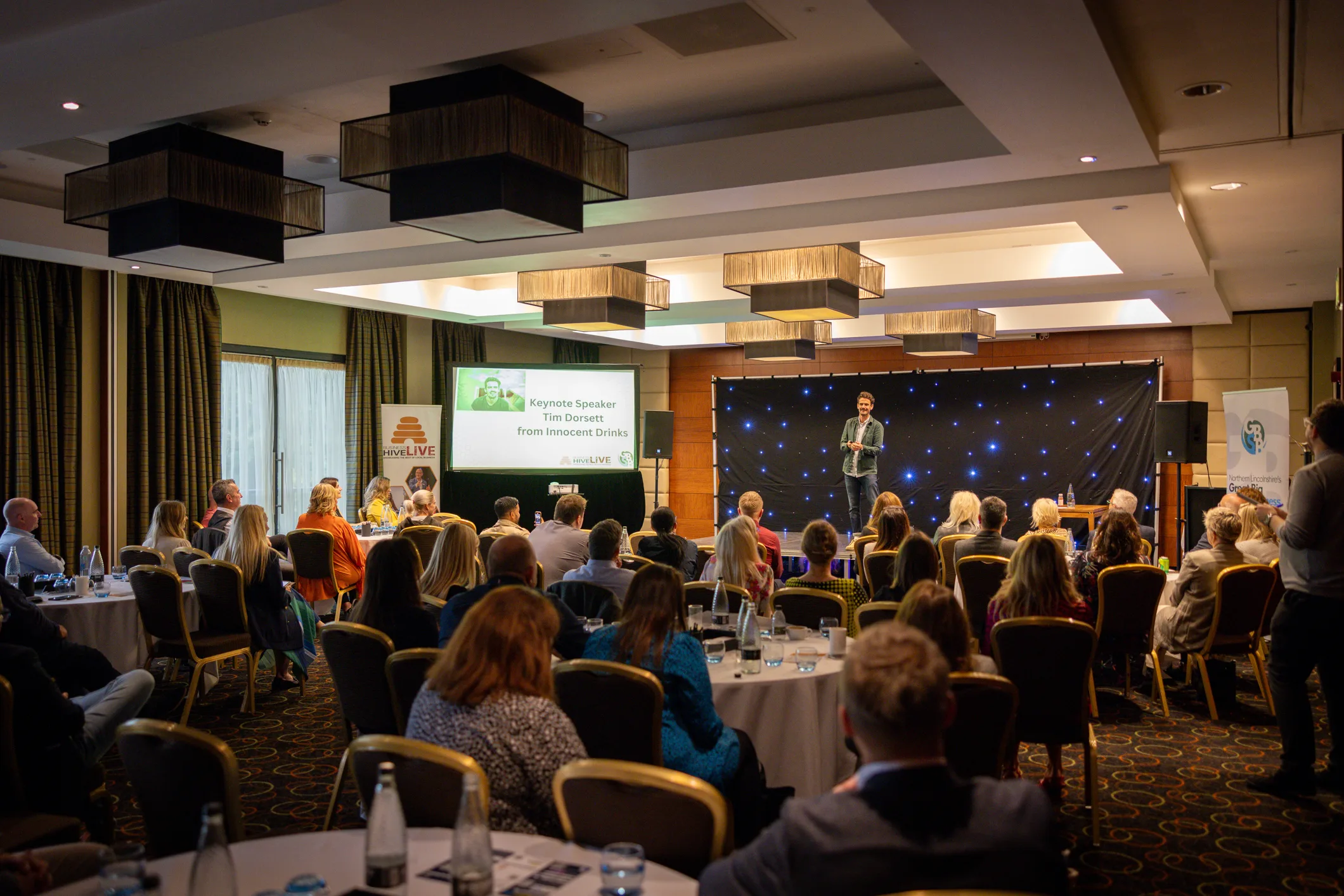 Wide view of a conference presentation and stage