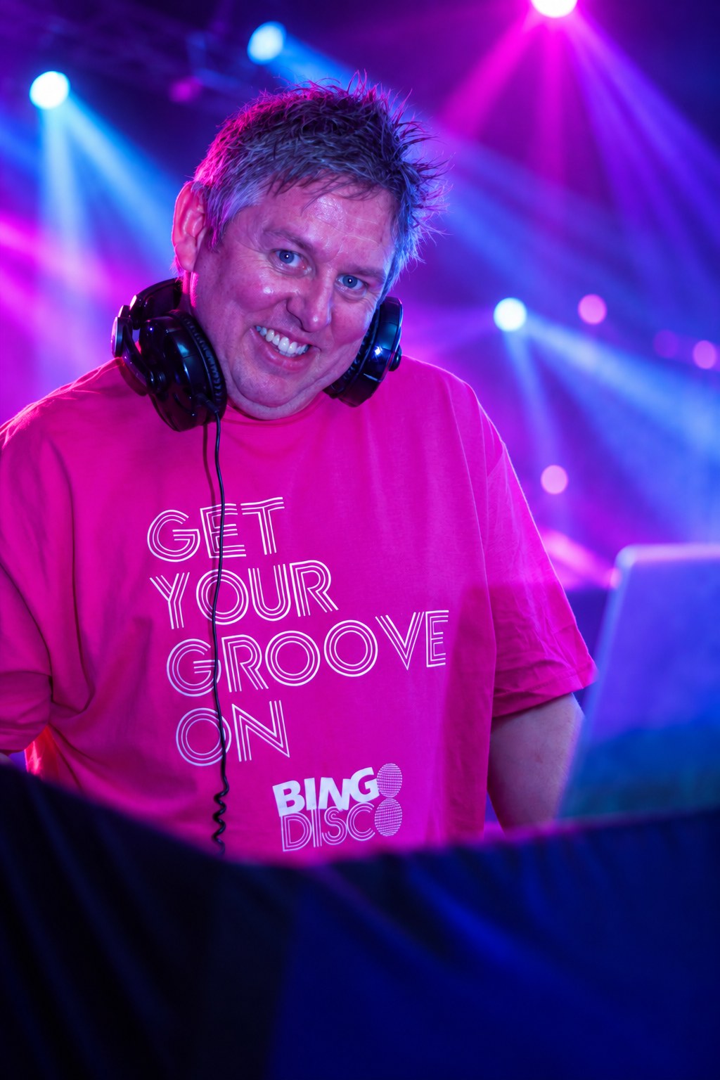 Bingo Disco DJ in a branded shirt behind the decks
